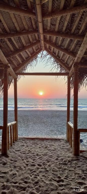 戈卡尔纳The Meraki Beach Resort Gokarna的海滩凉亭的日落美景