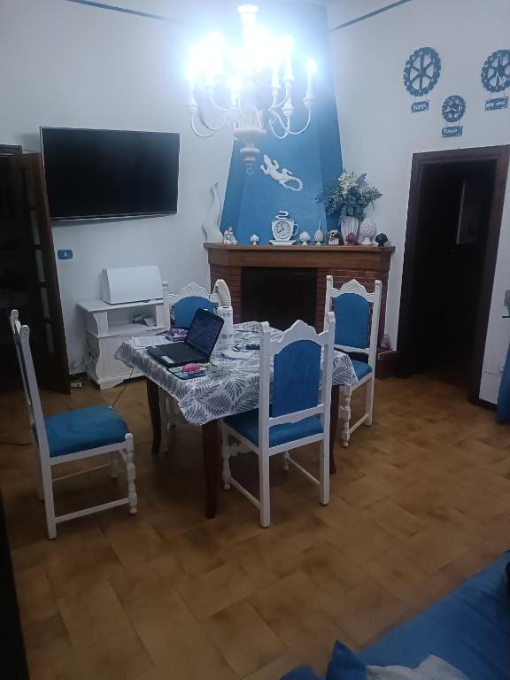 ein Esszimmer mit Tisch und Stühlen und einem Fernseher in der Unterkunft La Casa Dei Desideri in Oria