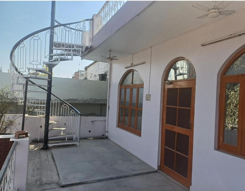 een wit gebouw met een trap en een deur bij Swati Heritage Homes in Varanasi