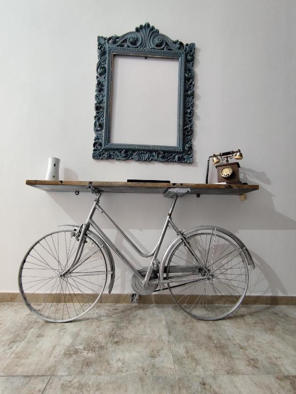 a bike parked next to a wall with a mirror at John's House in Sanremo