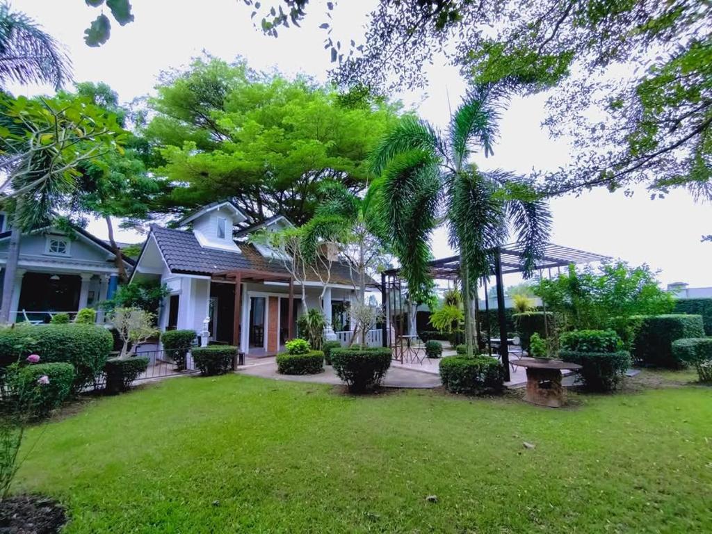a house with a yard with green grass at Rosie Garden & Home in Na Jomtien