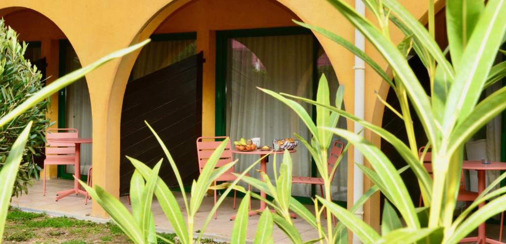 une table et des chaises devant une maison dans l'établissement Best Western Gemenos Villa Florette, à Gémenos