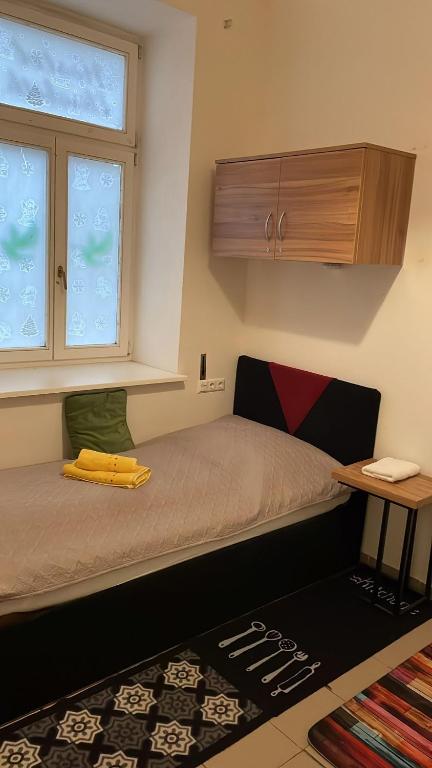 mała sypialnia z łóżkiem i oknem w obiekcie Elisabeth Hostel w Wiedniu