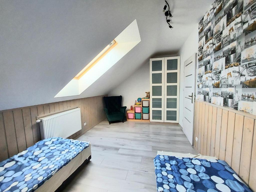 TyłowoKomfortowy Dom Całoroczny - sauna, jacuzzi, bilard的阁楼卧室设有床和窗户。