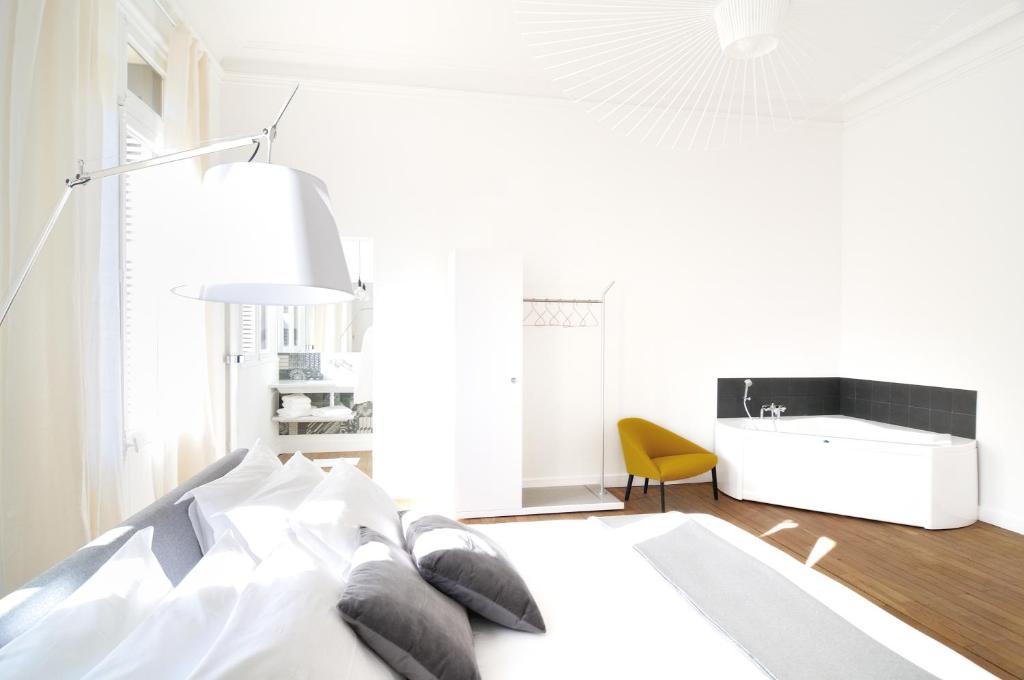 a white bedroom with a bed and a sink at L'Hôtel Particulier Beziers in Béziers
