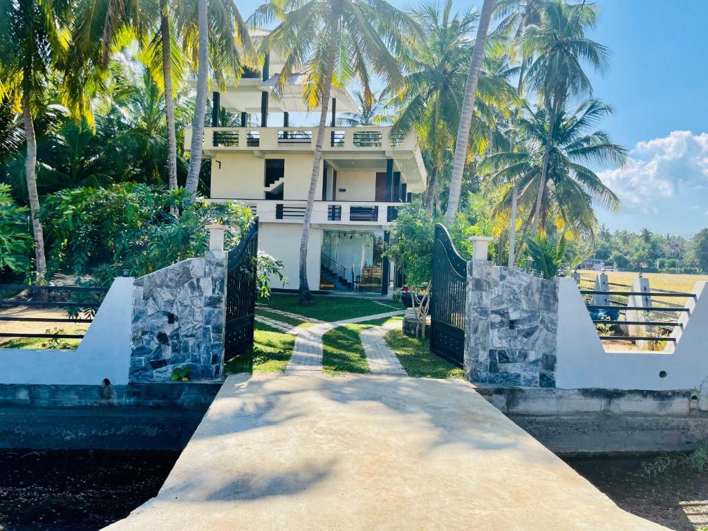 an exterior view of a house with palm trees at Tranquil Sanctuary Yala in Tissamaharama