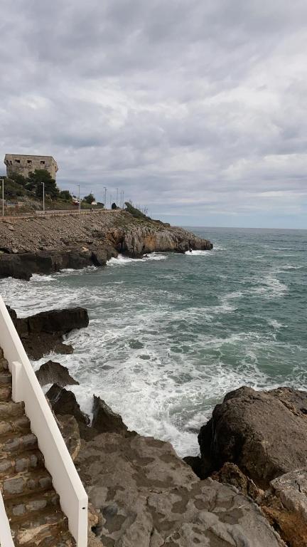 a set of stairs leading to the ocean with waves at Residencial Algaida in Oropesa del Mar