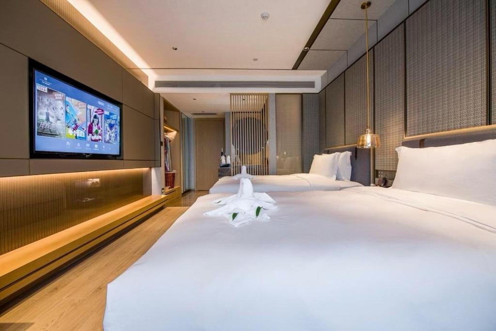 Postel nebo postele na pokoji v ubytování LIZ International Hotel Panyu Ginza Shiqiao Metro Branch - Free Shuttle Bus to Canton Fair Complex During Canton Fair Period & Free Breakfast & Free Afternoon Tea & Free Midnight Snack