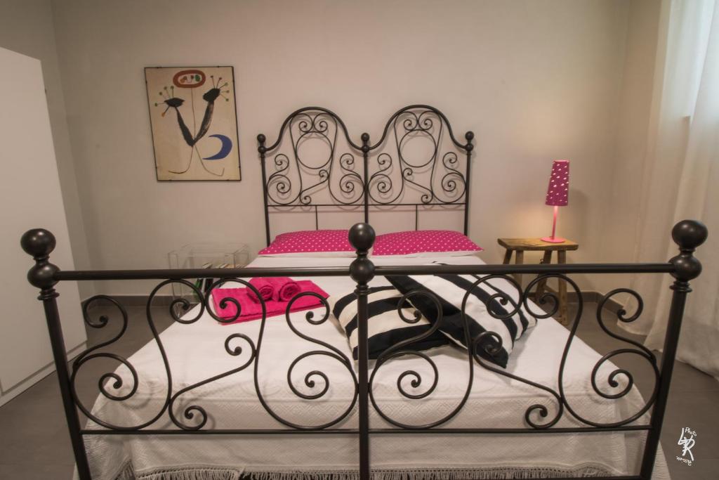 ポルト・レカナーティにあるB&B Mar del Plataのベッドルーム1室(ピンクの枕が付いた黒いベッド1台付)