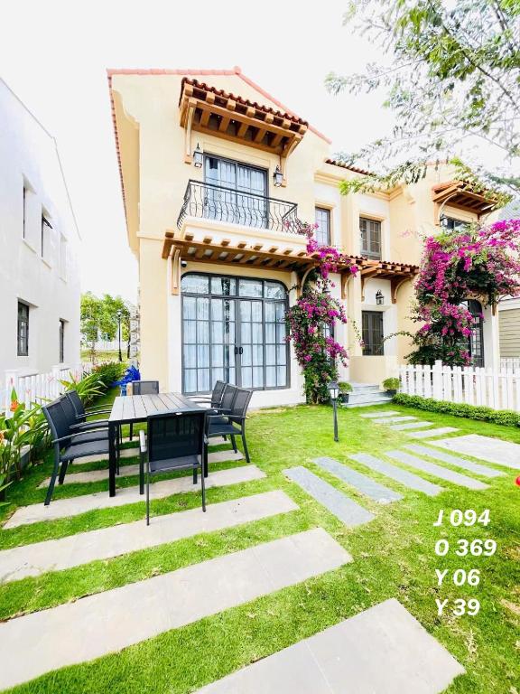 a patio with a table and chairs in front of a house at JOYY Villa 4PN-3WC-5 giường NovaWorld Phan Thiết in Bình Tú