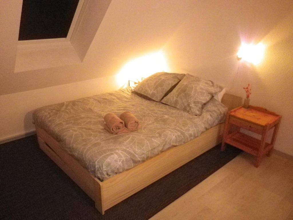 a bedroom with a bed with two slippers on it at Charmant duplex avec belle vue mer la plage à 100 m in Saint-Nic