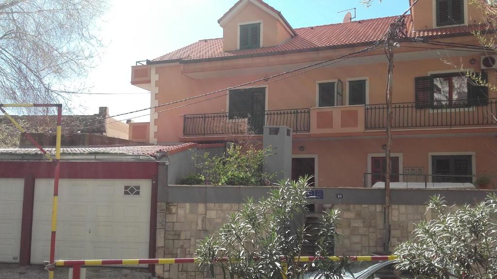 een groot roze huis met een witte garage bij Villa Miranda - Croazia in Omiš