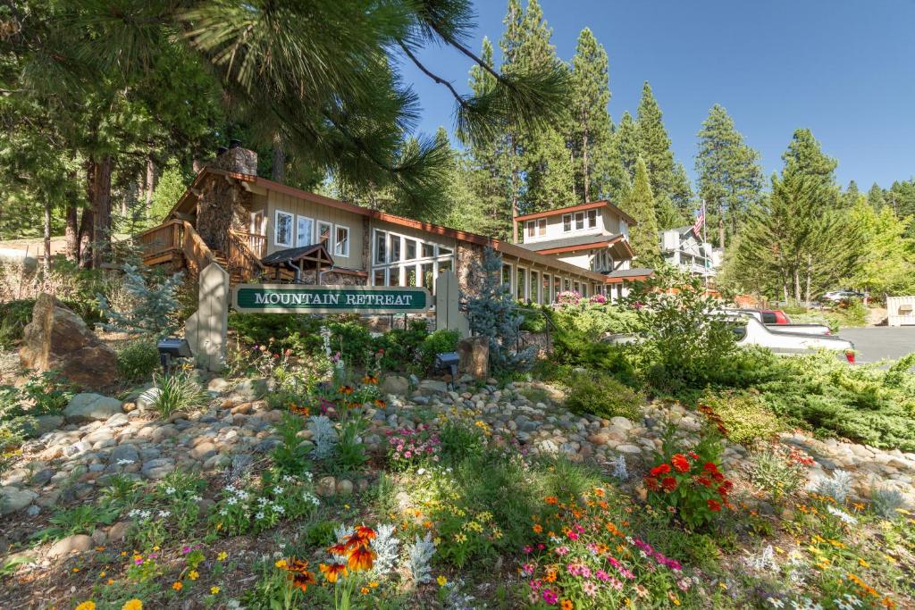 een huis met een bord in een tuin met bloemen bij Mountain Retreat Resort, a VRI resort in Arnold