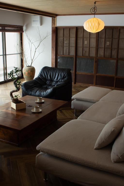 a living room with a couch and a coffee table at TEIEN stay sauna in Ōtani