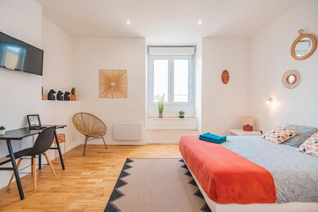une chambre avec un lit, une table et un bureau dans l'établissement Stuart élégance vue Cathédrale, à Reims