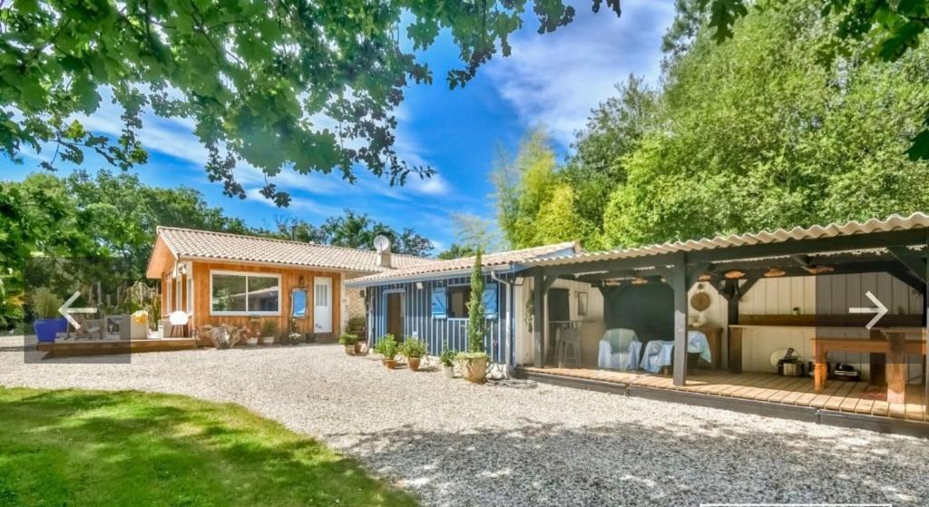 une maison avec un patio et une maison dans l'établissement Bilydis, à Vendays-Montalivet