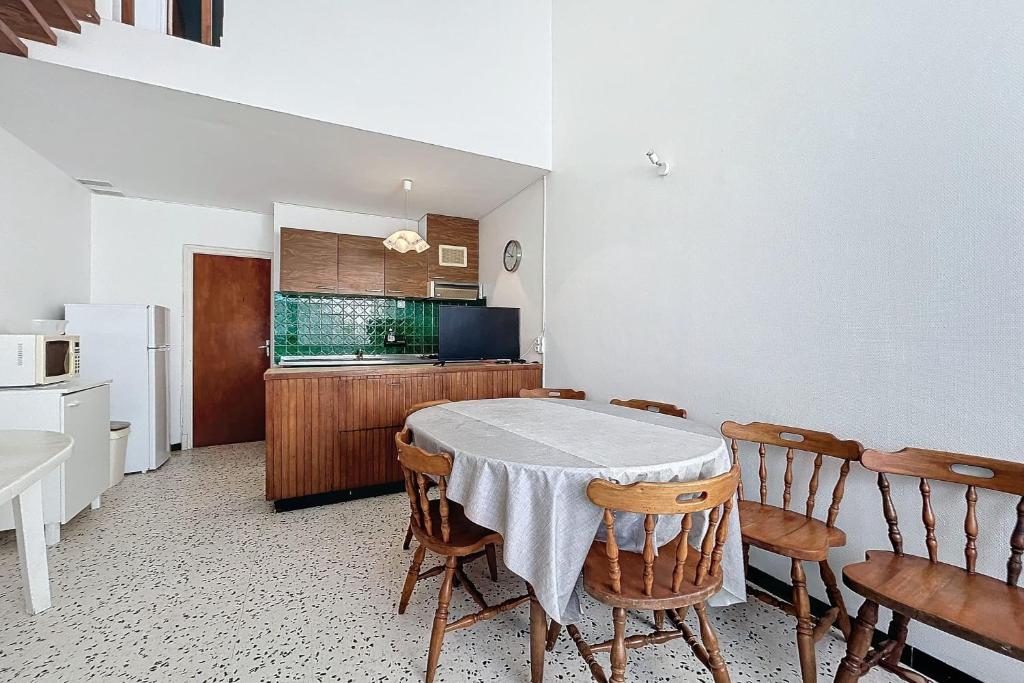 une cuisine avec une table et des chaises dans une pièce dans l'établissement Spacious house near the beach, à Port-la-Nouvelle