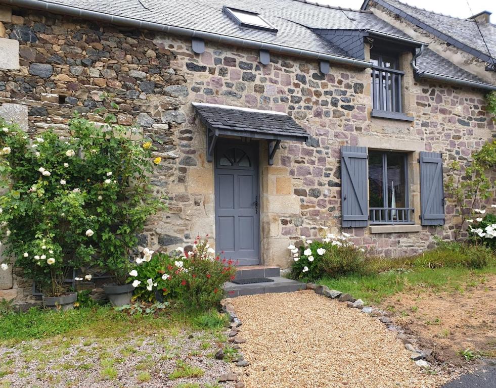 une ancienne maison en pierre avec une porte bleue et des fleurs dans l'établissement Charming quiet cottage -3 bedrooms - Private garden, à Pléboulle