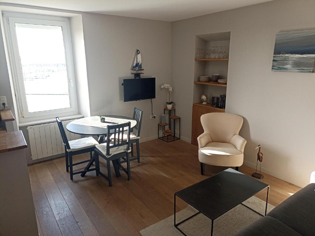 un salon avec une table et des chaises dans l'établissement Appartement Saint-Malo vue mer, à Saint-Malo