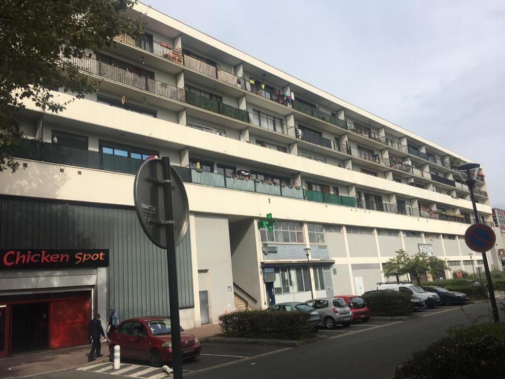 un grand bâtiment blanc avec des voitures garées devant dans l'établissement Spacieux appartement 3 chambres, à Massy