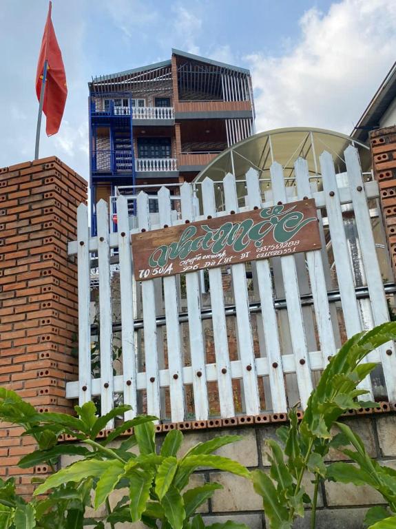 a white picket fence in front of a building at Homestay Nhà Mộc in Da Lat