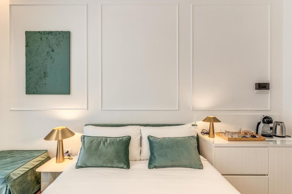 a bedroom with a white bed with two green pillows at ArtPartment in Naples
