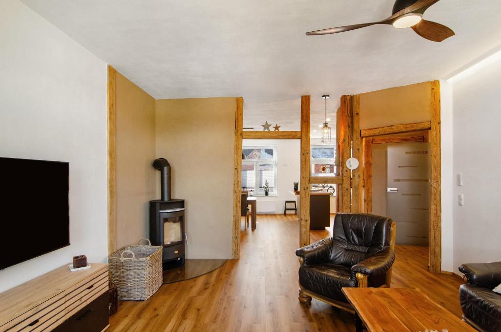 a living room with a tv and a couch and a chair at Ferienwohnung Eichendorff in Nordhausen