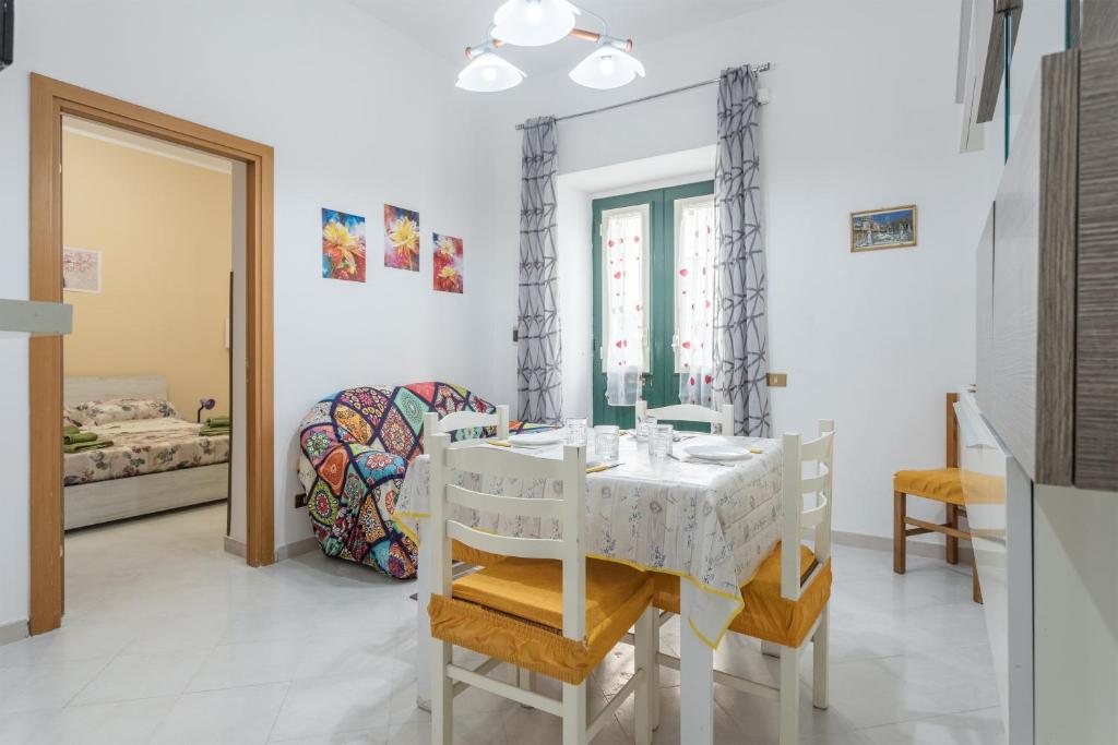 een witte eetkamer met een tafel en stoelen bij Casa Silvana in Palermo