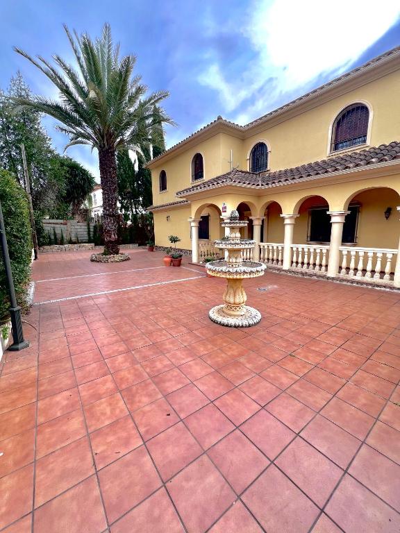 a large courtyard with a fountain in front of a building at El Carmen in Córdoba