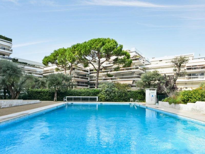 une grande piscine bleue devant un immeuble dans l'établissement 3P Mas de Tanit au calme avec piscine, à Juan-les-Pins