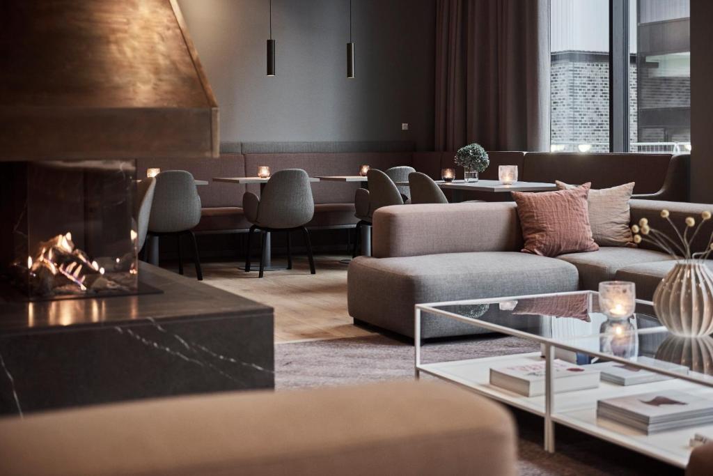 a living room with a couch and a fireplace at Hotel Odeon in Odense