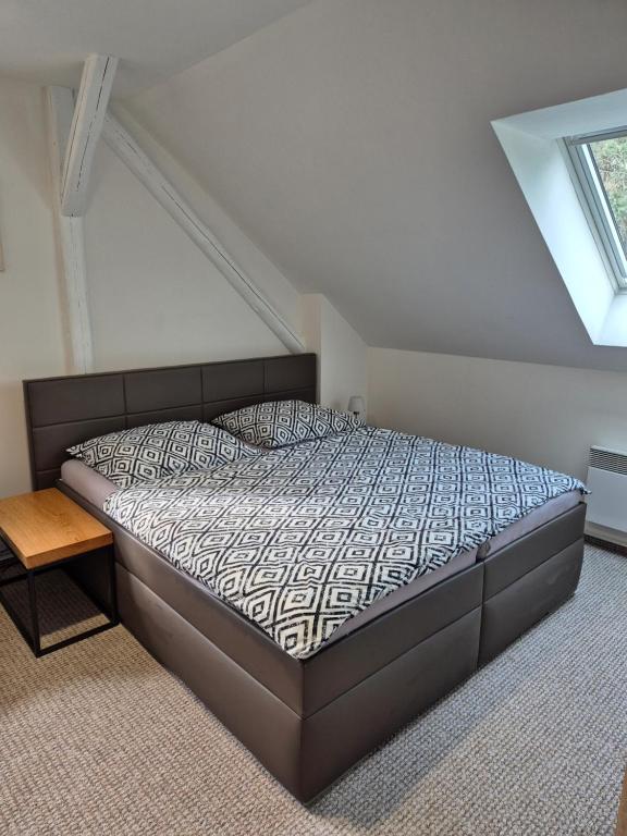 sypialnia z łóżkiem w pokoju z oknem w obiekcie Apartmans Les w Zlinie