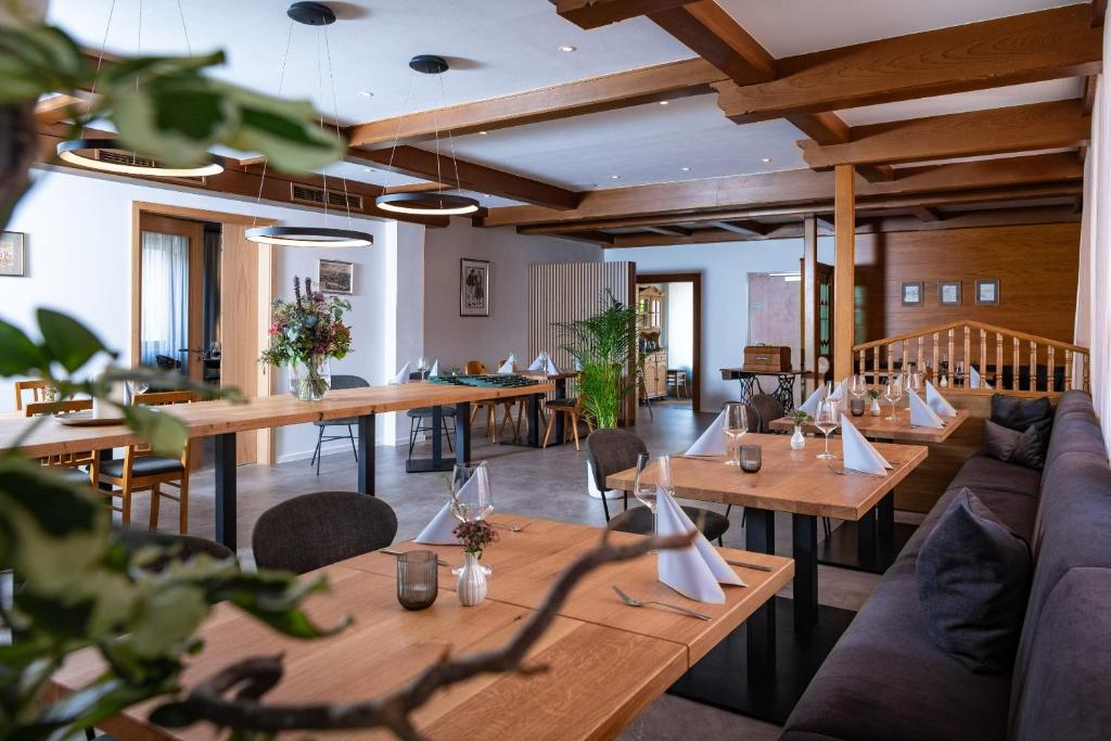 a restaurant with wooden tables and couches and chairs at Hotel Landgasthof zum Kaffelstein in Kreuzwertheim