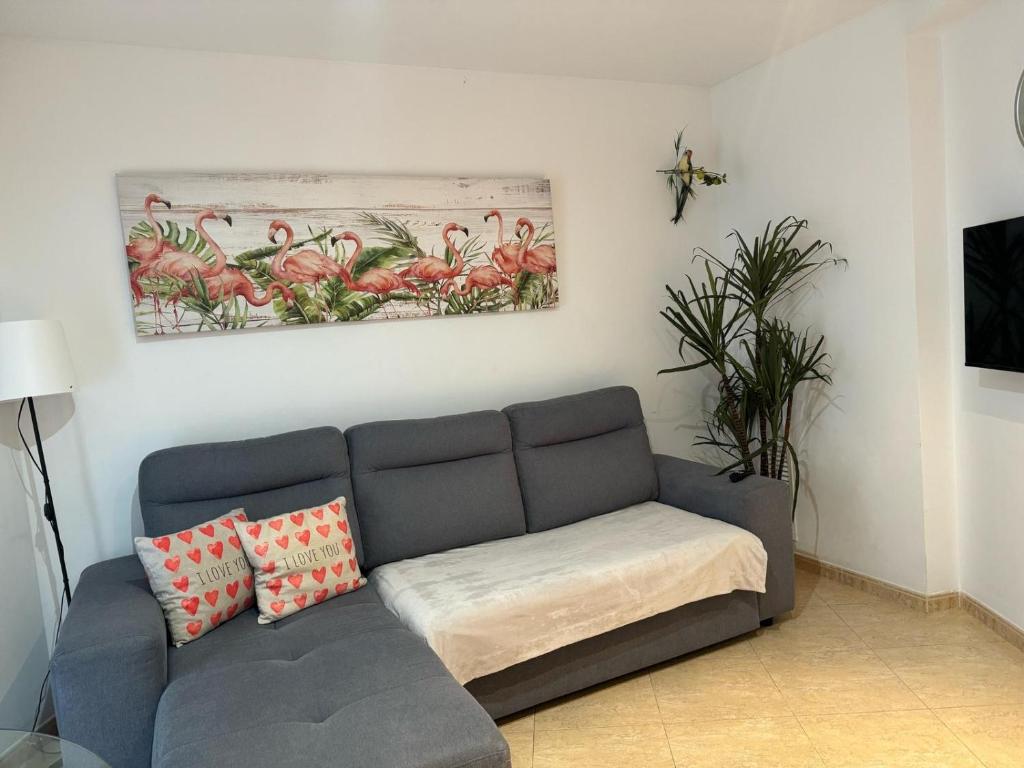 a living room with a couch and a painting on the wall at Parrot’s House in Lloret de Mar