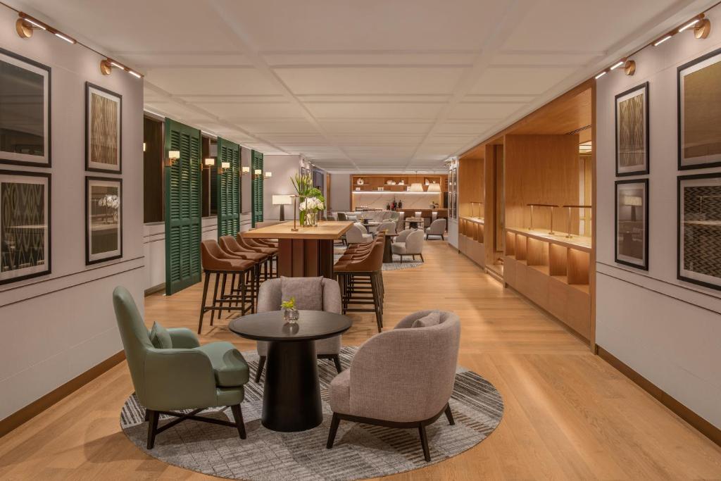 A contemporary lobby lounge with armchairs, tables, and a service counter.