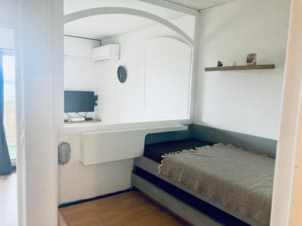 mały pokój z łóżkiem i biurkiem w obiekcie Hyeres port bel appartement w Hyères