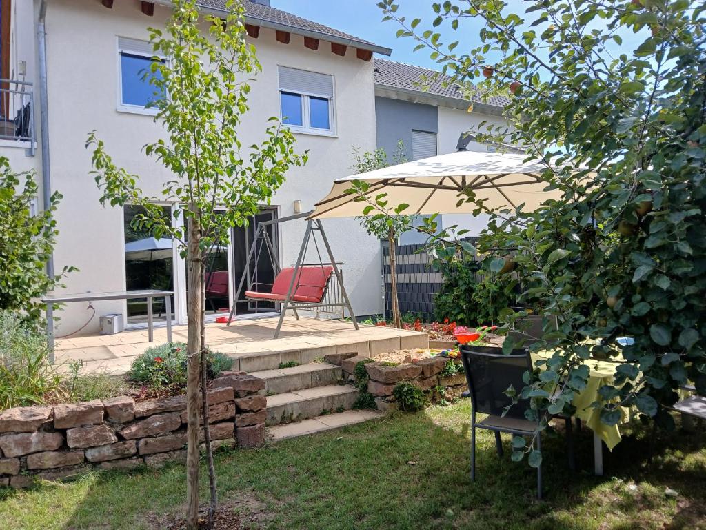 - un jardin avec une chaise et un parasol dans l'établissement Fewo Gartenblick Altlußheim - Netflix- parken - Küche - Klimaanlage - Shuttle zum Hockenheimring, à Altlußheim