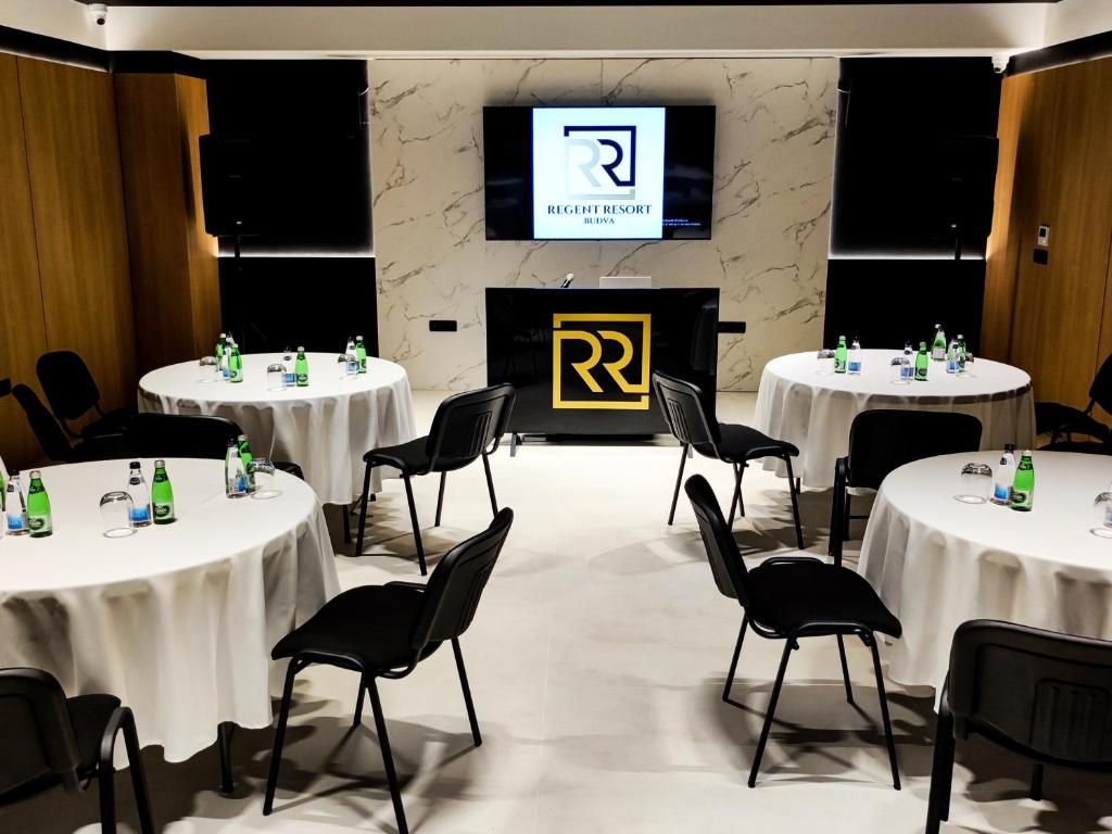 a room with four tables and chairs and a tv at Regent Resort Budva in Budva