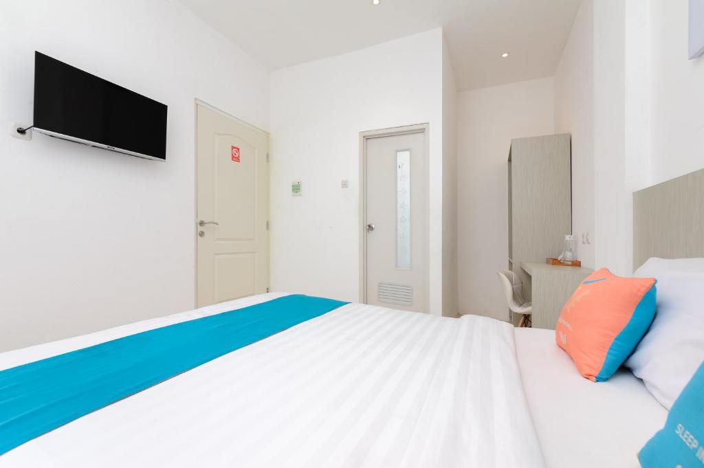 Postel nebo postele na pokoji v ubytování Sans Hotel La Vida Malang