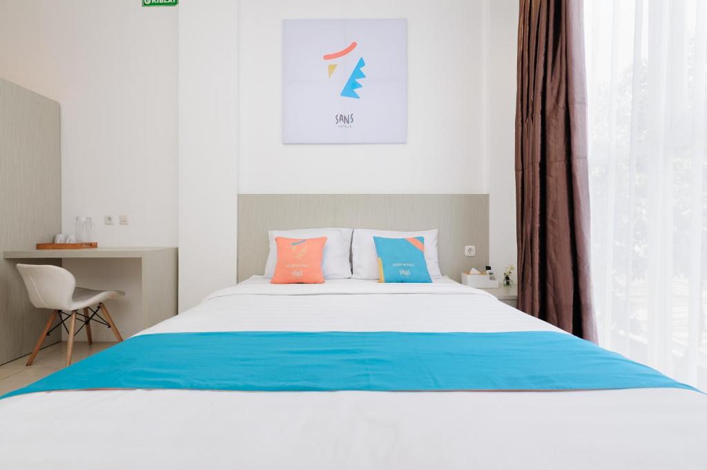Postel nebo postele na pokoji v ubytování Sans Hotel La Vida Malang