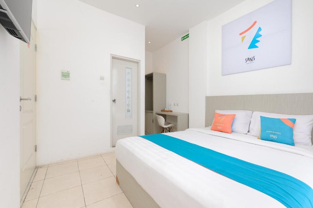Postel nebo postele na pokoji v ubytování Sans Hotel La Vida Malang