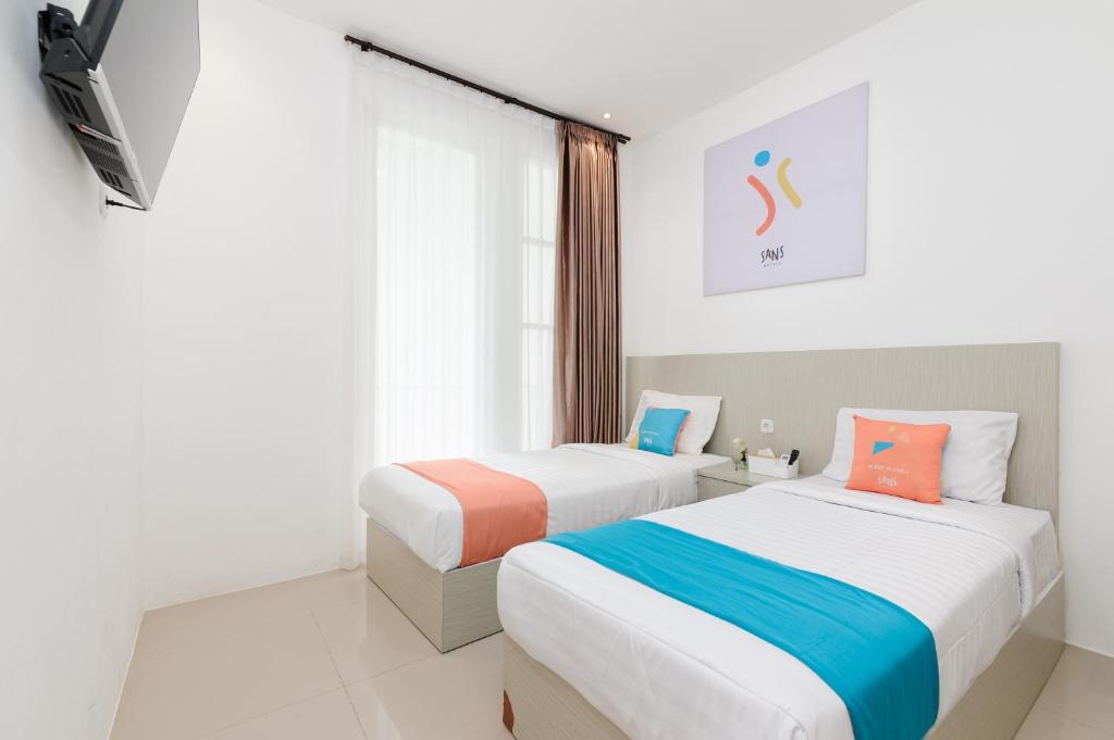Postel nebo postele na pokoji v ubytování Sans Hotel La Vida Malang
