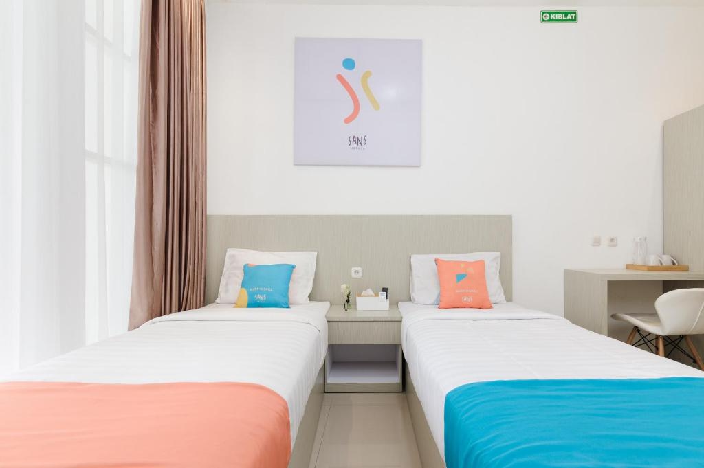 Postel nebo postele na pokoji v ubytování Sans Hotel La Vida Malang