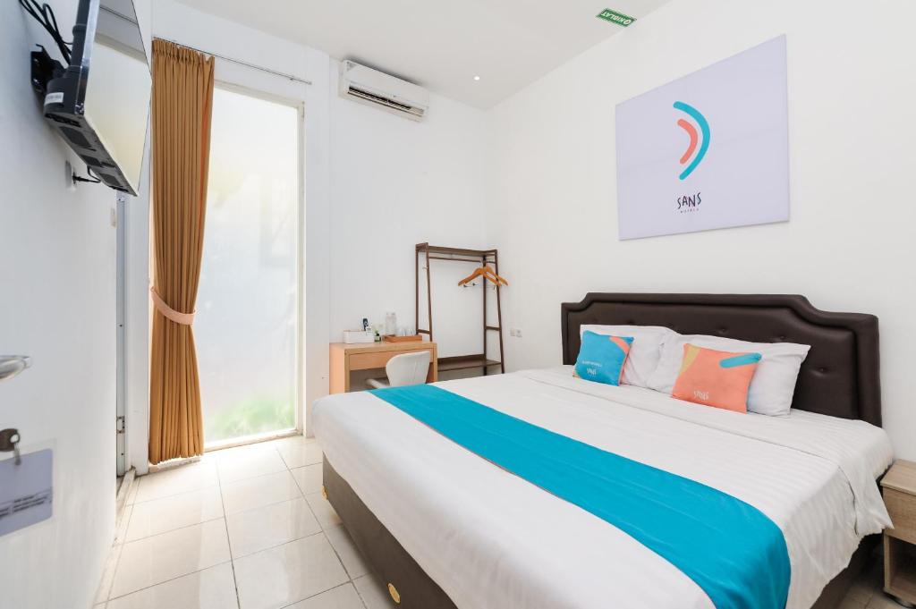 Postel nebo postele na pokoji v ubytování Sans Hotel La Vida Malang