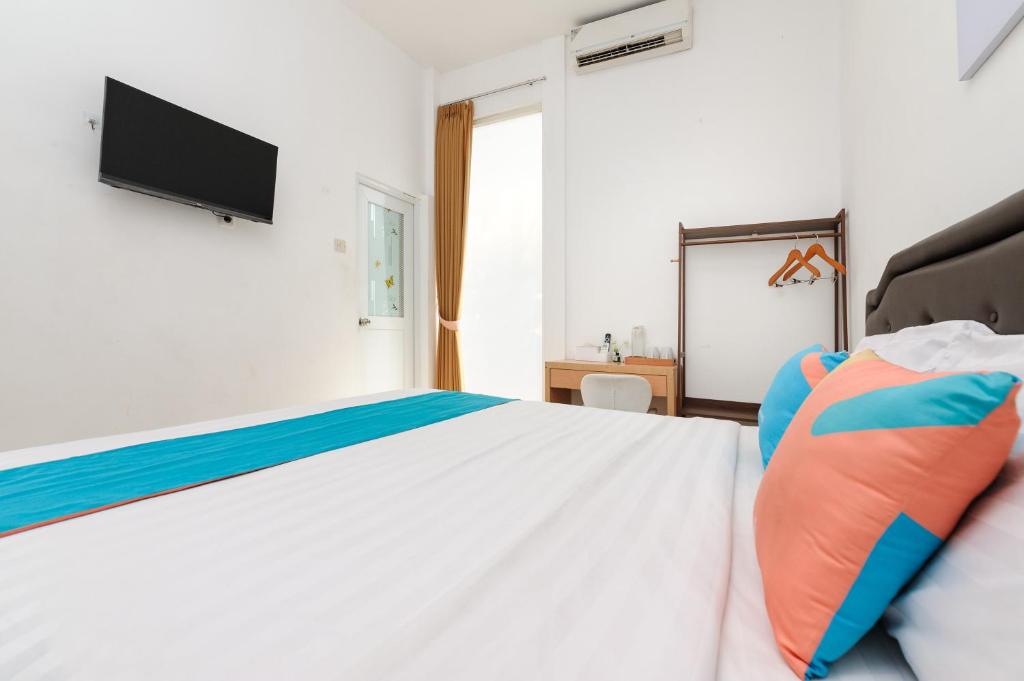 Postel nebo postele na pokoji v ubytování Sans Hotel La Vida Malang