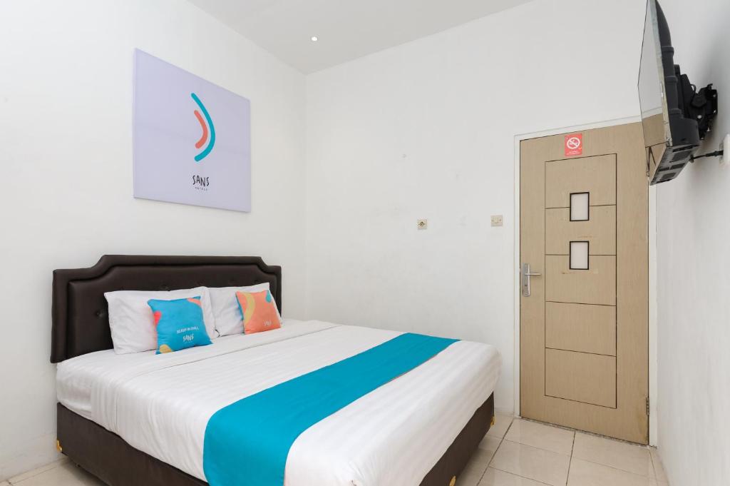 Postel nebo postele na pokoji v ubytování Sans Hotel La Vida Malang