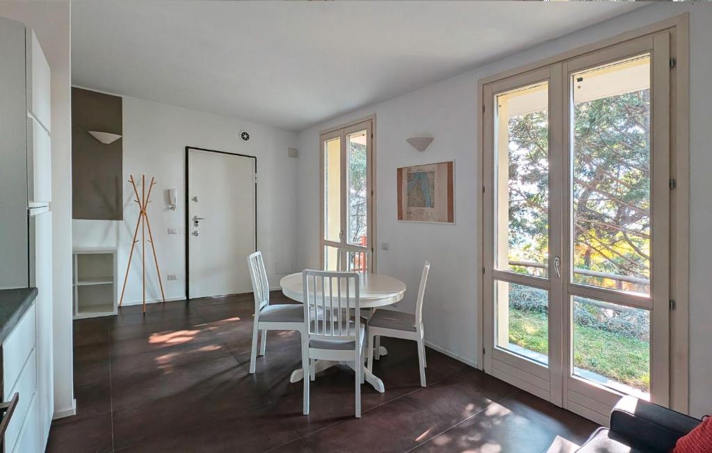 una sala da pranzo con tavolo, sedie e finestre di La piccola coccinella a Bellagio