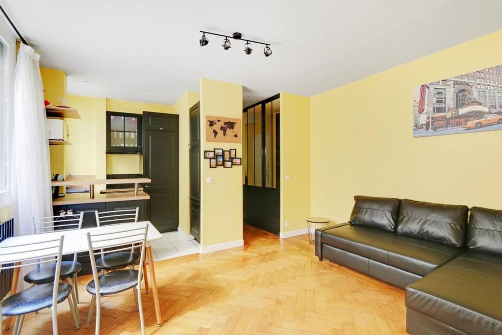 un salon avec un canapé et une table dans l'établissement Bright getaway near Montparnasse, à Paris