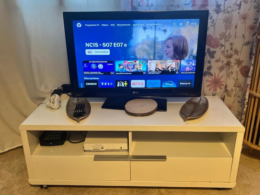 une télévision assise sur un meuble blanc dans l'établissement Appartement confortable, à Rennes