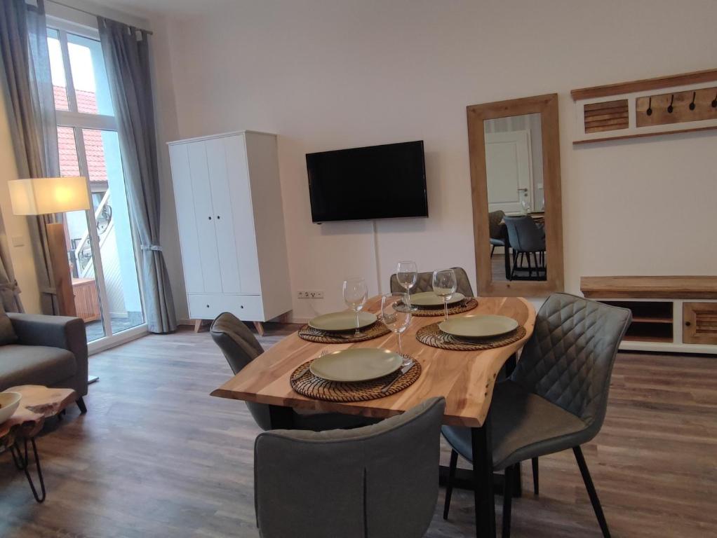 a living room with a wooden table and chairs at Villa Boberg Apartments in Ostseebad Koserow